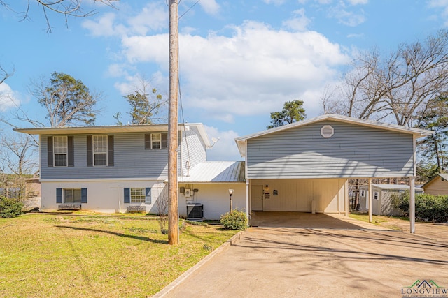 view of front facade with concrete driveway, a front yard, central AC unit, metal roof, and a carport