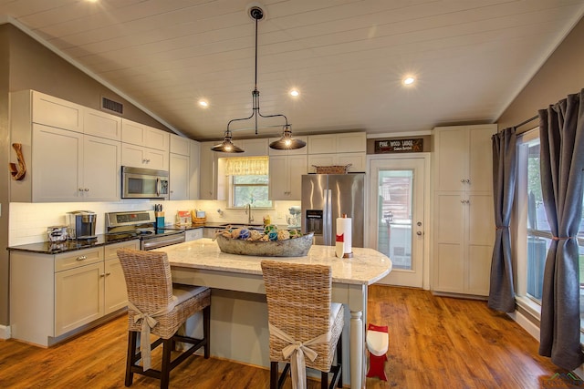 209 Rocky Point Rd, Mount Vernon, TX 75457 - kitchen with stainless steel appliances, vaulted ceiling, tasteful backsplash, a center island, and recessed lighting