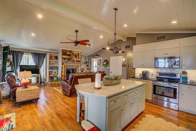 209 Rocky Point Rd, Mount Vernon, TX 75457 - kitchen with stainless steel appliances, open floor plan, a center island, ceiling fan, and light wood-style flooring