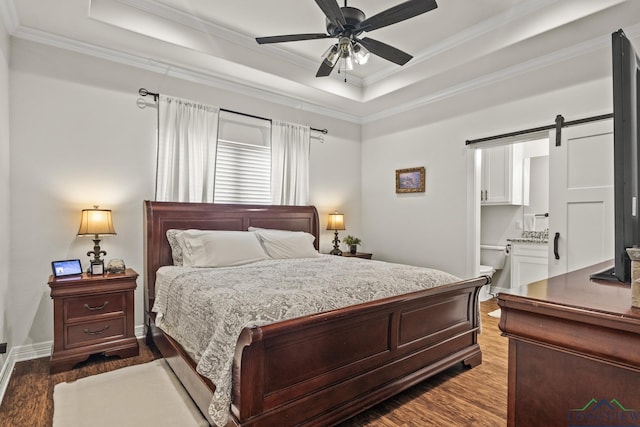 bedroom featuring a tray ceiling, a barn door, ceiling fan, and hardwood / wood-style flooring