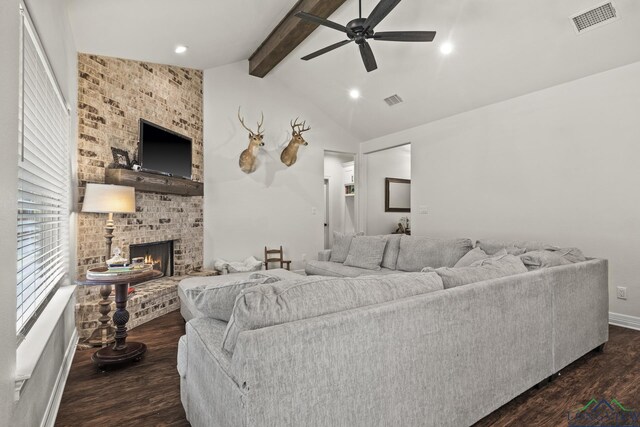 living room featuring vaulted ceiling with beams, ceiling fan, dark hardwood / wood-style flooring, and a brick fireplace