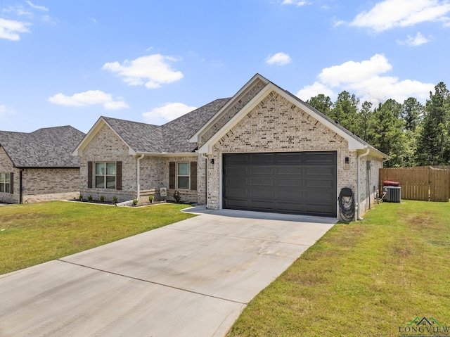 view of front of property with central AC unit, a front yard, and a garage