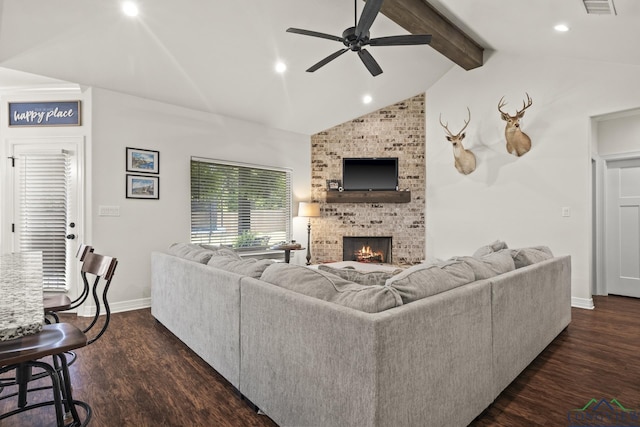 living room with vaulted ceiling with beams, ceiling fan, a fireplace, and dark hardwood / wood-style flooring