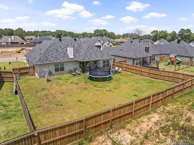 exterior space with a playground, a yard, and a trampoline