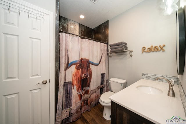 bathroom featuring toilet, a textured ceiling, vanity, wood finished floors, and a shower with curtain