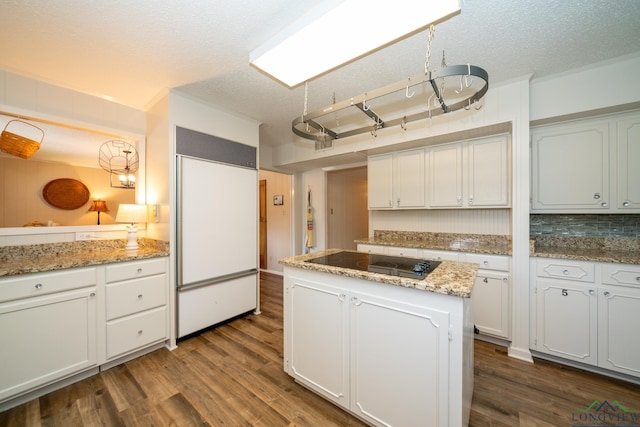 kitchen with dark wood-type flooring, a center island, black electric stovetop, paneled refrigerator, and white cabinets