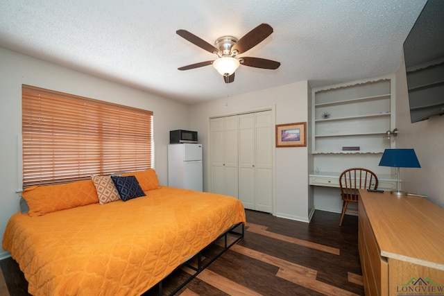 bedroom featuring a textured ceiling, a ceiling fan, a closet, freestanding refrigerator, and dark wood-style floors