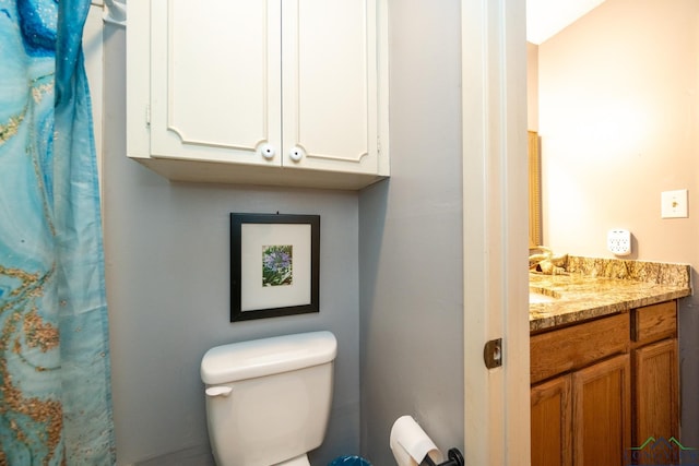 bathroom featuring walk in shower, vanity, and toilet