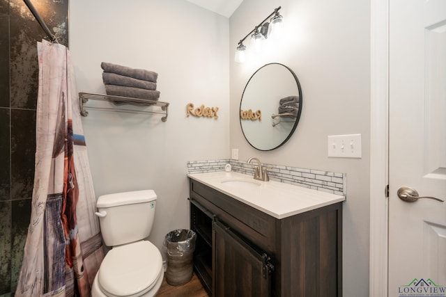 bathroom with vanity, backsplash, and toilet