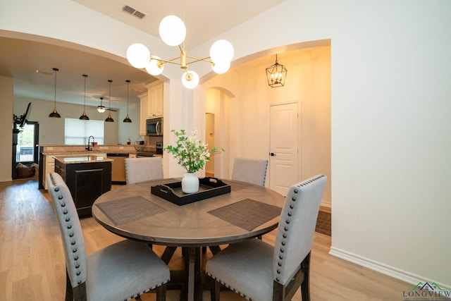 dining area featuring light hardwood / wood-style floors, an inviting chandelier, and sink