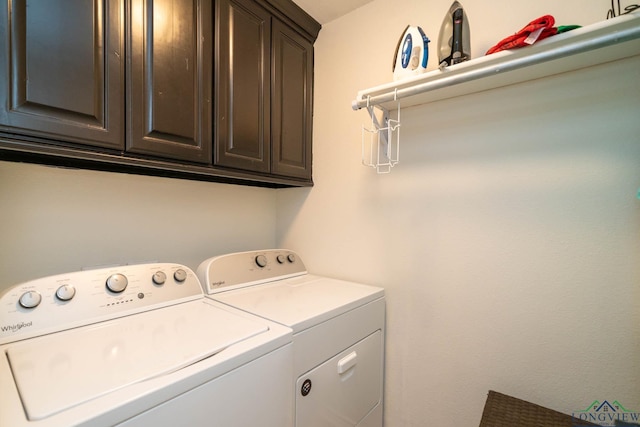 clothes washing area with cabinets and washing machine and clothes dryer