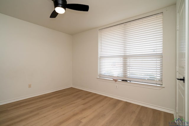 empty room with ceiling fan and light hardwood / wood-style flooring