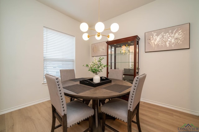 dining space featuring light hardwood / wood-style floors and a chandelier