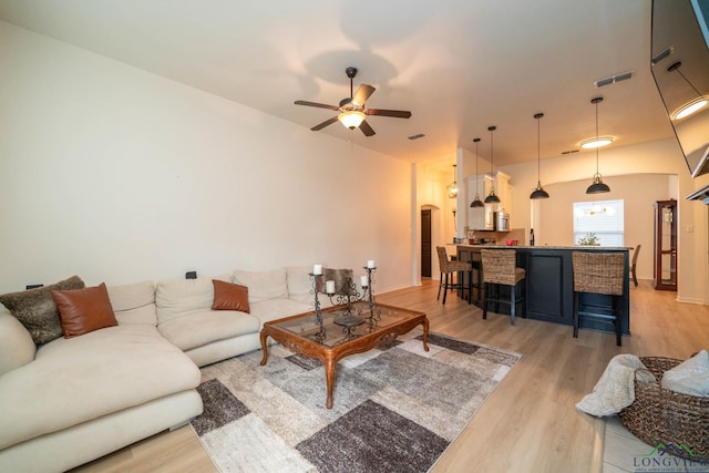 living room with ceiling fan and light hardwood / wood-style flooring