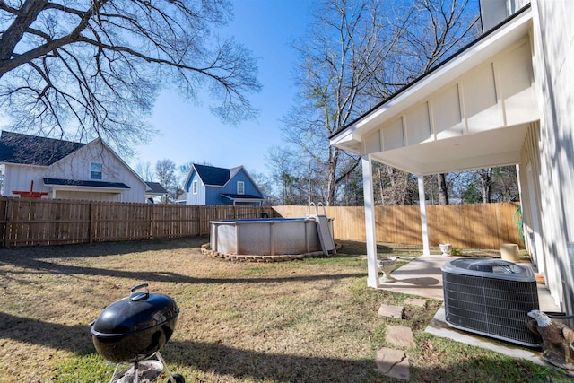 view of yard with a fenced in pool and central air condition unit