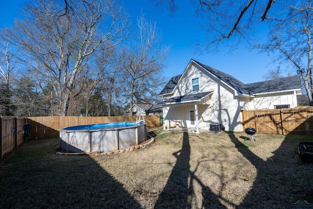 view of yard featuring a fenced in pool and central AC unit