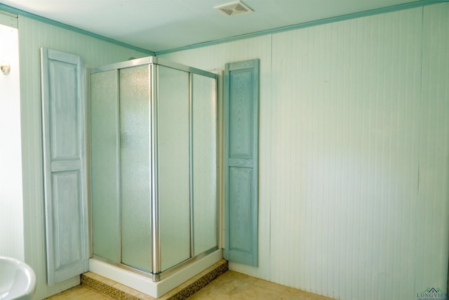 bathroom featuring tile patterned floors and a shower with shower door