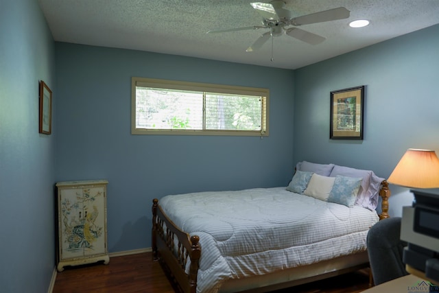 bedroom featuring ceiling fan, dark hardwood / wood-style floors, and a textured ceiling