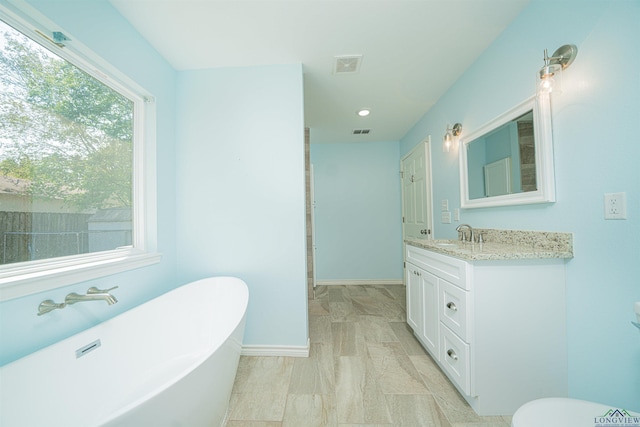 bathroom featuring vanity and a bath