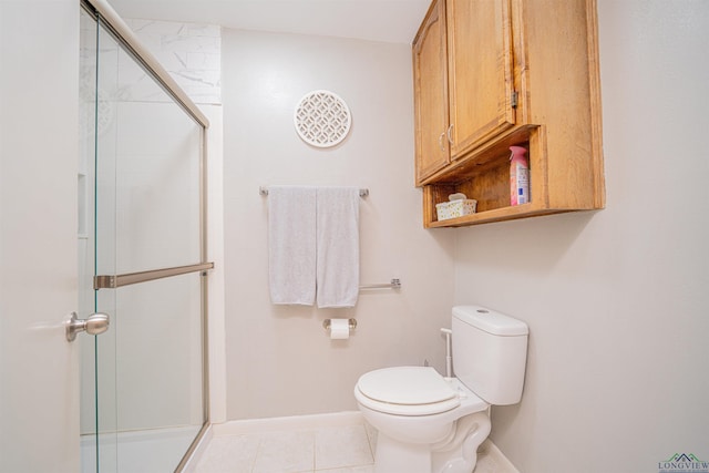 bathroom featuring toilet, a shower with shower door, and tile patterned flooring