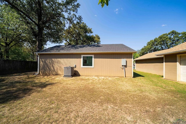 rear view of property featuring cooling unit and a yard