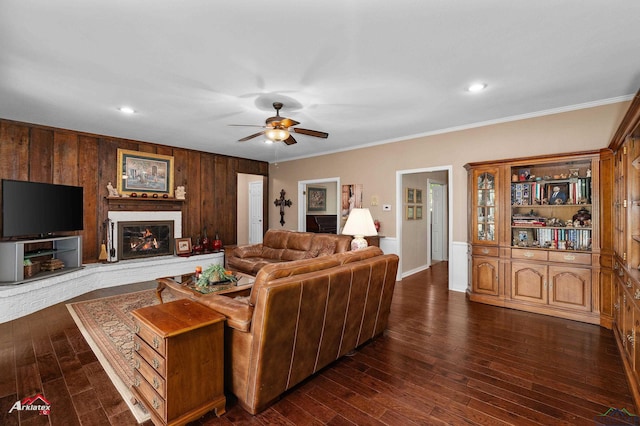 106 Brachfield Rd, Henderson, TX 75654 - living area featuring a ceiling fan, crown molding, wood walls, dark wood finished floors, and a glass covered fireplace