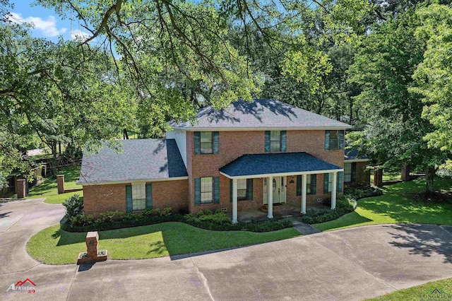 106 Brachfield Rd, Henderson, TX 75654 - view of front of home with a front yard, brick siding, a porch, and driveway
