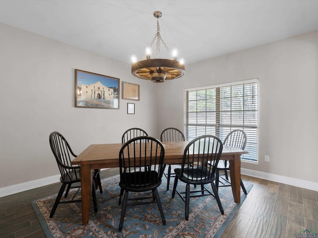 dining room with dark hardwood / wood-style floors and a notable chandelier