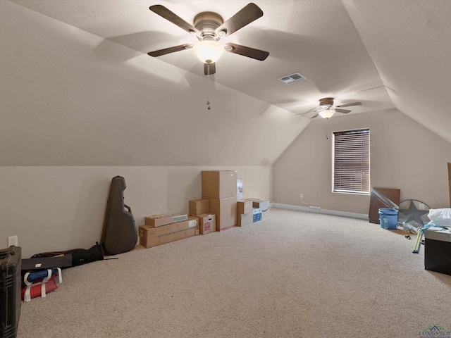 bonus room with a textured ceiling, vaulted ceiling, ceiling fan, and carpet flooring