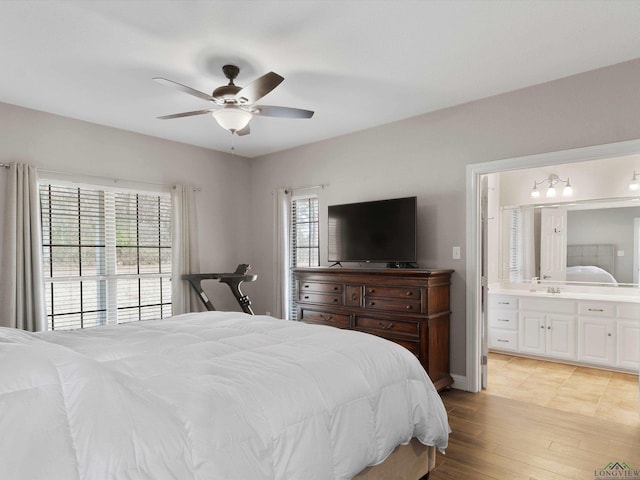 bedroom with ensuite bathroom, ceiling fan, and light wood-type flooring