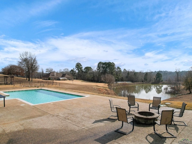 view of pool featuring a water view, a patio area, and a fire pit