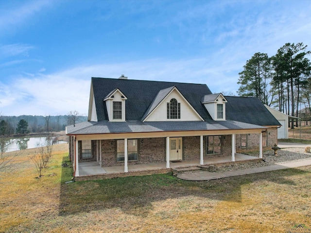 view of front of property with a water view, a front yard, and a patio area