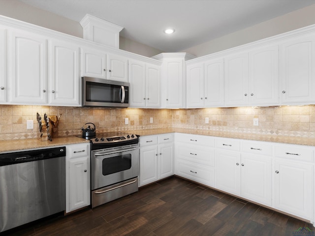 kitchen featuring dark hardwood / wood-style flooring, decorative backsplash, white cabinets, and appliances with stainless steel finishes