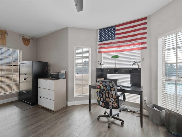 office with hardwood / wood-style flooring and a healthy amount of sunlight