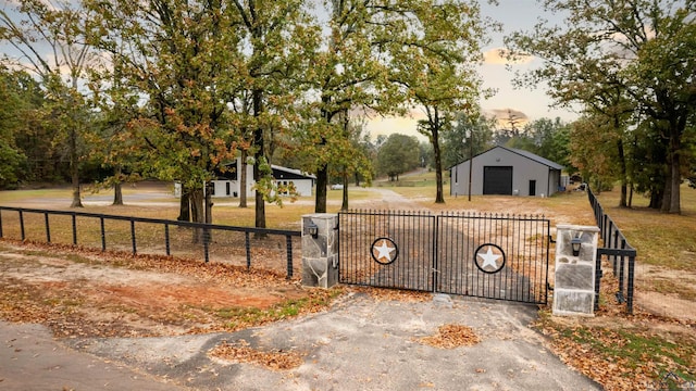 gate at dusk with an outdoor structure and a lawn