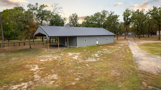 property exterior at dusk featuring an outbuilding