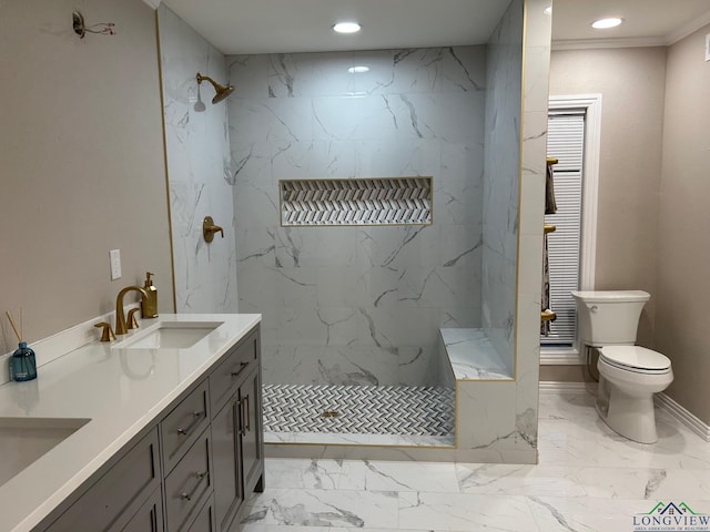 bathroom featuring a tile shower, toilet, vanity, and ornamental molding