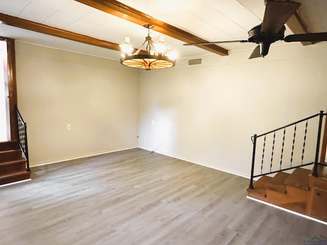 713 Martha Dr, Gladewater, TX 75647 - spare room with beam ceiling, stairway, wood finished floors, a chandelier, and baseboards
