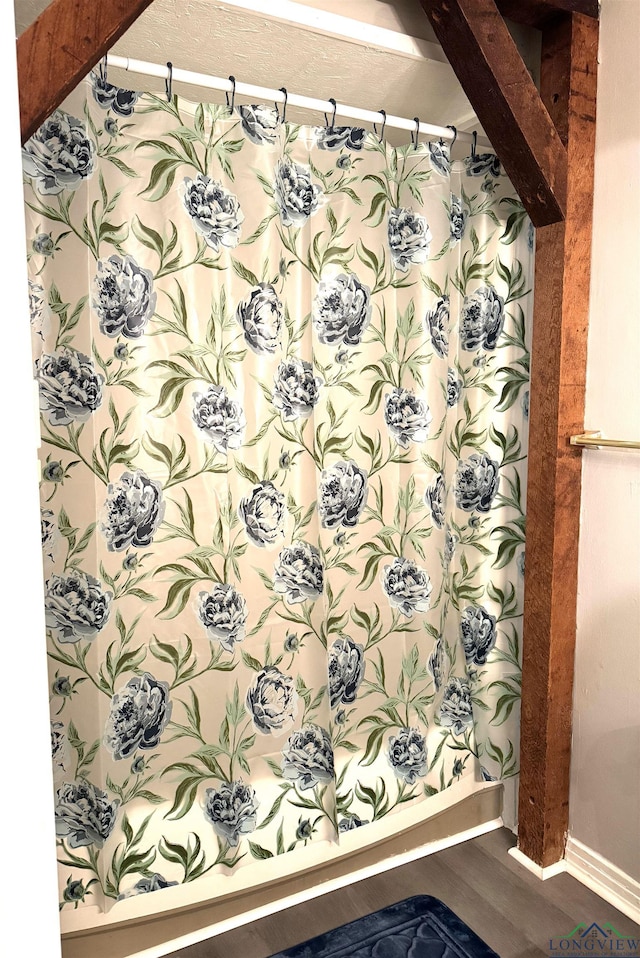 713 Martha Dr, Gladewater, TX 75647 - full bath featuring wood finished floors, a shower with shower curtain, and baseboards