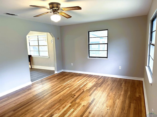 713 Martha Dr, Gladewater, TX 75647 - spare room featuring healthy amount of natural light, arched walkways, wood finished floors, and baseboards