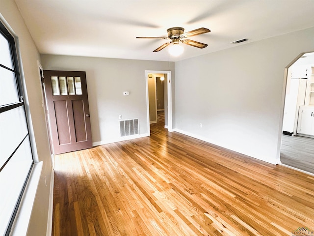 713 Martha Dr, Gladewater, TX 75647 - unfurnished living room featuring a ceiling fan, wood finished floors, arched walkways, and baseboards