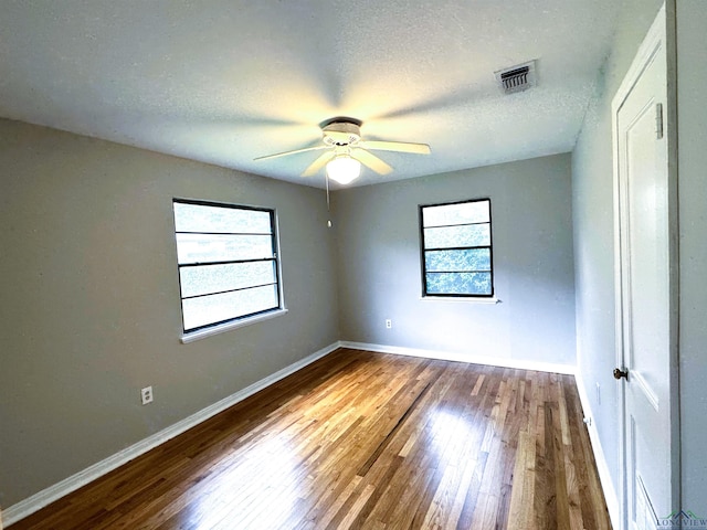 713 Martha Dr, Gladewater, TX 75647 - empty room featuring wood finished floors, ceiling fan, baseboards, and a textured ceiling