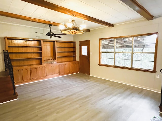 713 Martha Dr, Gladewater, TX 75647 - unfurnished living room featuring wood finished floors, beamed ceiling, a chandelier, ceiling fan, and baseboards