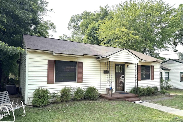 713 Martha Dr, Gladewater, TX 75647 - ranch-style home with a front lawn, cooling unit, and a shingled roof