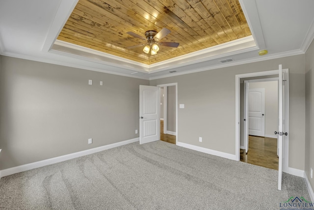 unfurnished bedroom with a tray ceiling, crown molding, and wooden ceiling