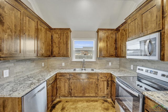 kitchen with light stone countertops, sink, appliances with stainless steel finishes, and tasteful backsplash