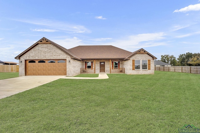 view of front of property featuring covered porch, a front yard, and a garage