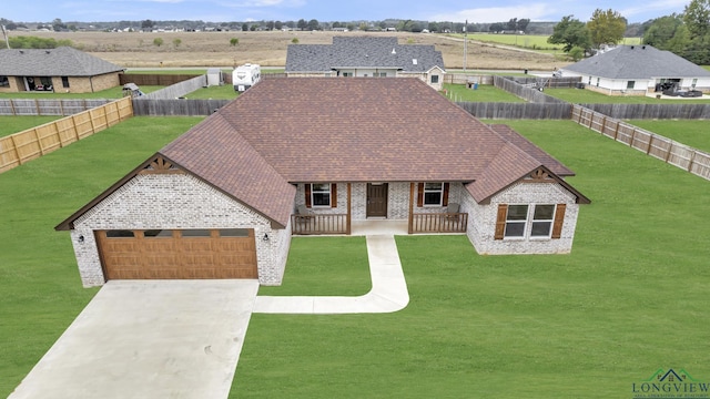 view of front of house featuring covered porch, a front yard, and a garage