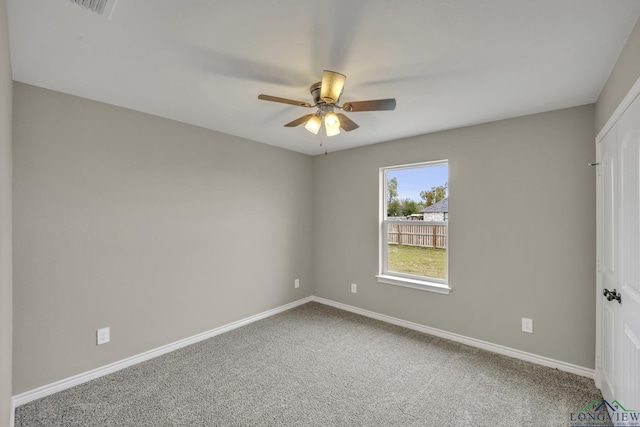 carpeted spare room featuring ceiling fan