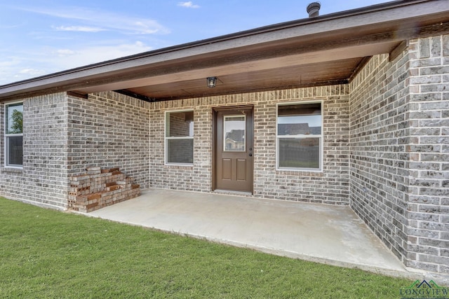 view of exterior entry featuring a patio